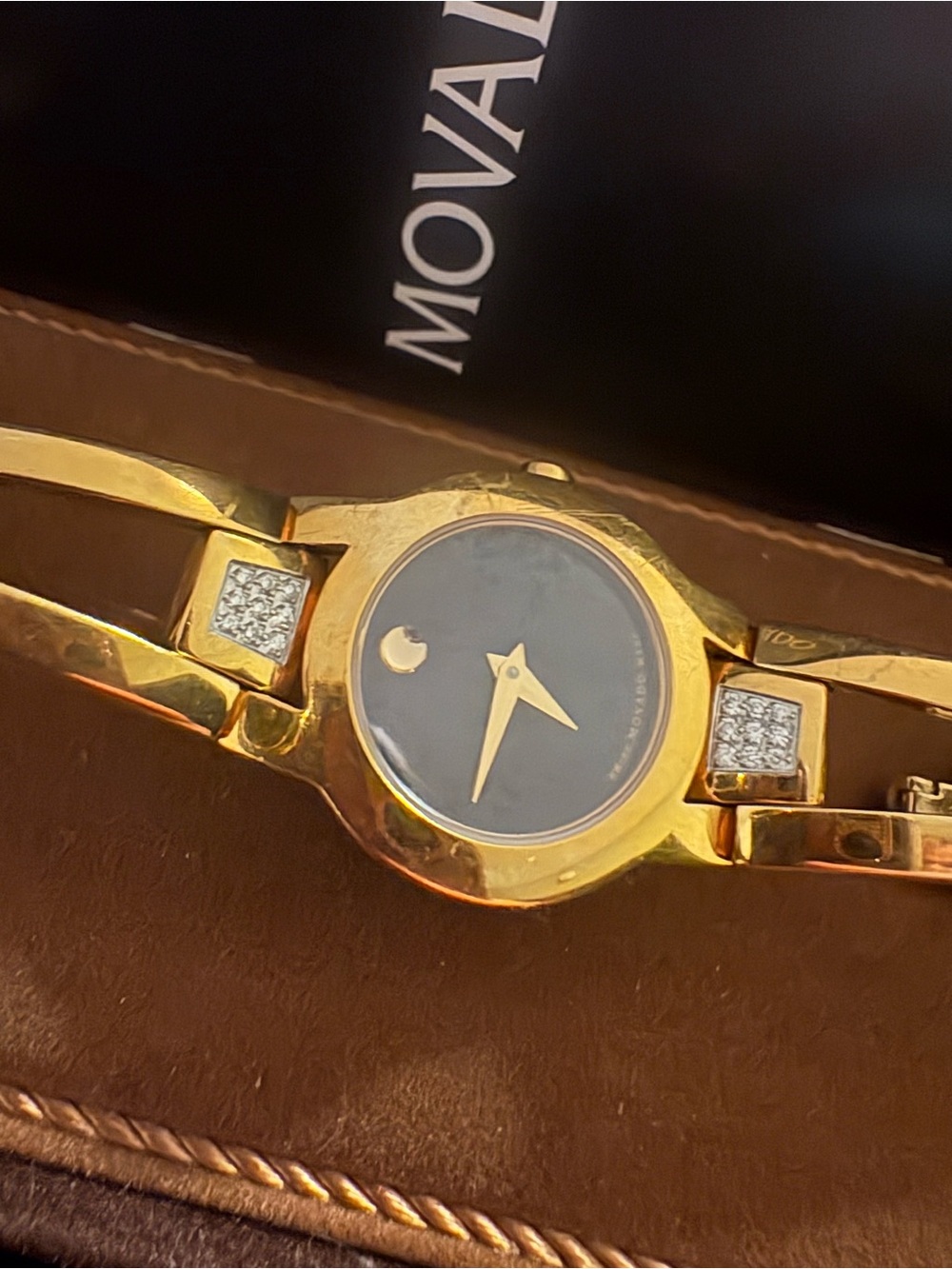 Movado Gold-Tone Bangle Watch with Black Dial and 18 diamonds.